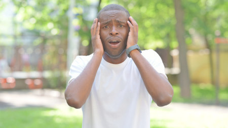 Young African Man Reacting to Failure Outdoor in Parkの写真素材