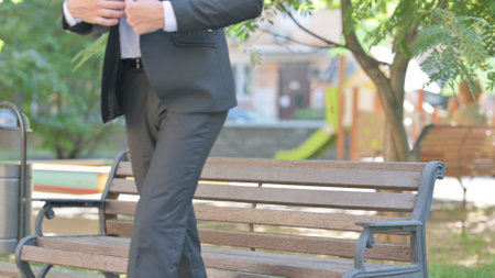 Young Businessman Leaving Bench in Parkの写真素材