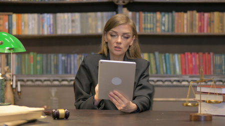 Female Lawyer Doing Video Chat on Tablet in Officeの写真素材
