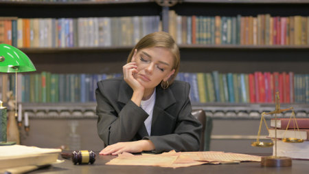 Female Lawyer Sleeping while Sitting in Officeの写真素材