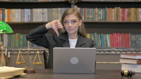 Female Lawyer with Thumbs Down Working on Laptopの写真素材