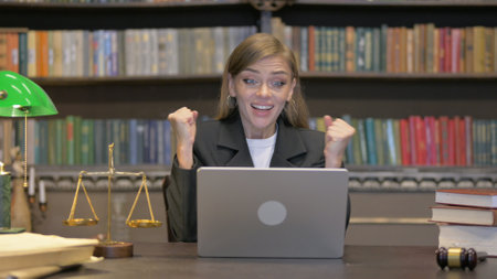 Female Lawyer Celebrating Success on Laptopの写真素材