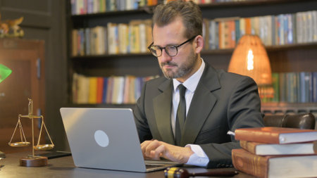 Middle Aged Lawyer Working on Laptop in Officeの写真素材