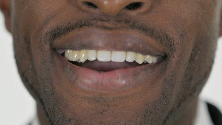 Close up of Smiling African Male Lips on White Backgroundの写真素材