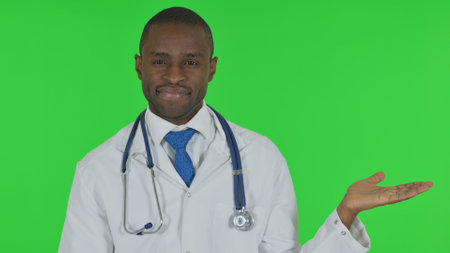 Portrait of African Doctor Showing Copyspace on Green Backgroundの写真素材
