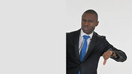 Portrait of African Businessman with Thumbs Down on White Backgroundの写真素材