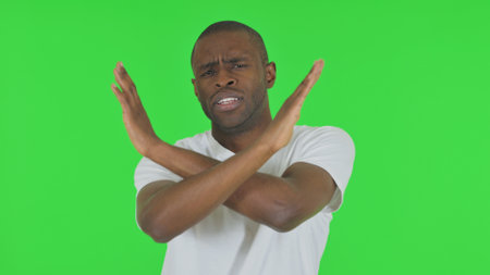 Portrait of Rejecting African Man Disliking Offer on Green Backgroundの写真素材