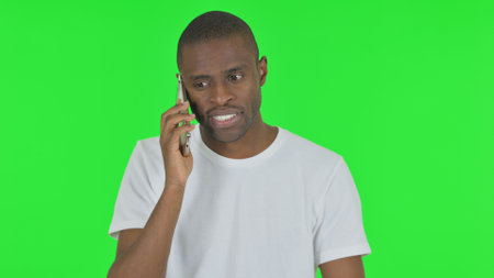 Portrait of African Man Talking on phone on Green Backgroundの写真素材