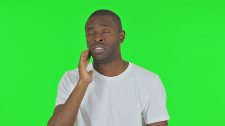 Portrait of African Man with Tooth Pain on Green Backgroundの写真素材