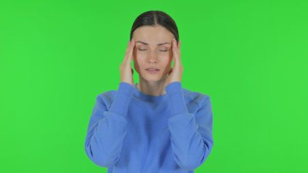 Woman with Headache on Green Backgroundの写真素材