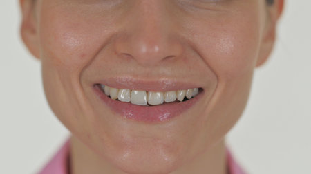 Close up of Smiling Female Lips on White Backgroundの写真素材