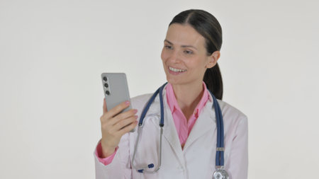 Portrait of Female Doctor Doing Video Chat via Phone on White Backgroundの写真素材