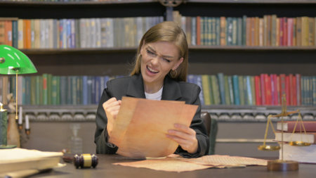 Reading Female Lawyer Enjoying Court Orders in Officeの写真素材