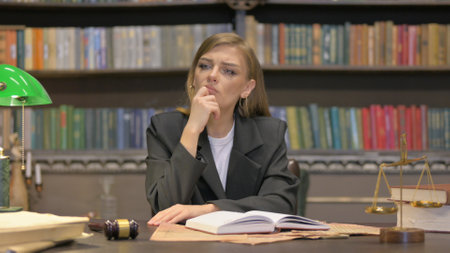 Pensive Female Lawyer Reading Book in Officeの写真素材