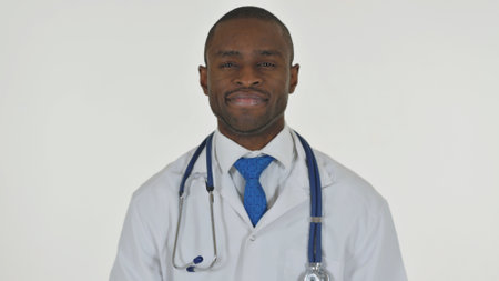 Portrait of African Doctor Shaking Head in Acceptance on White Backgroundの写真素材