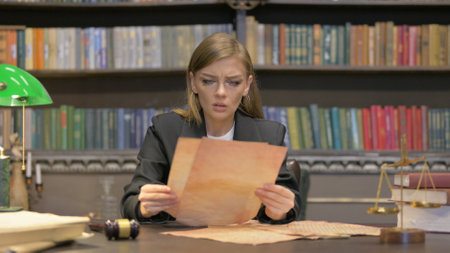 Tense Female Lawyer Shocked while Reading Court Orders in Officeの写真素材