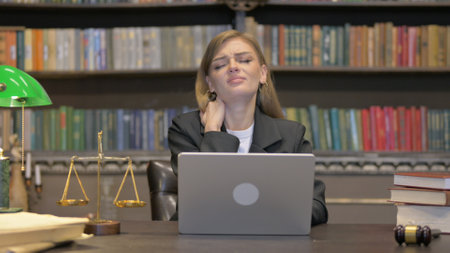 Female Lawyer having Neck Pain with Laptopの写真素材