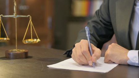 Close up of Male Judge Writing Verdict in Officeの写真素材
