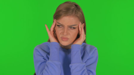 Woman with Headache on Green Backgroundの写真素材