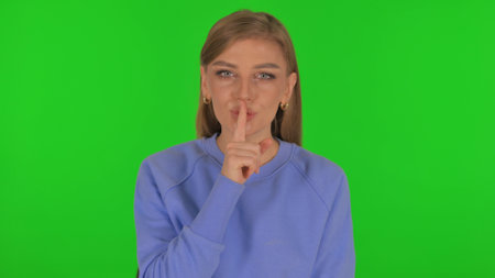 Woman with Silence Gesture on Green Backgroundの写真素材