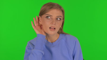 Woman Trying to Listen on Green Backgroundの写真素材
