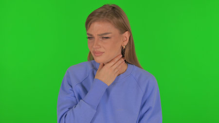 Sick Woman Coughing on Green Backgroundの写真素材