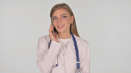 Portrait of Female Doctor Talking on phone on White Backgroundの写真素材