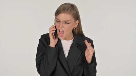 Portrait of Angry Businesswoman Talking on Phone on White Backgroundの写真素材
