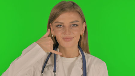 Portrait of Female Doctor inviting People for Help, Call Me on Green Backgroundの写真素材