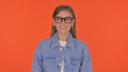 Smiling Casual Young Woman on Orange Background, Portraitの写真素材