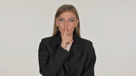 Portrait of Businesswoman with Finger on Lips on White Backgroundの写真素材