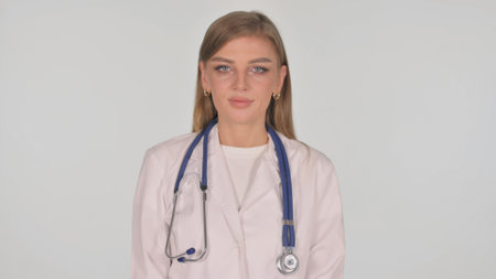Portrait of Female Doctor Shaking Head in Acceptance on White Backgroundの写真素材