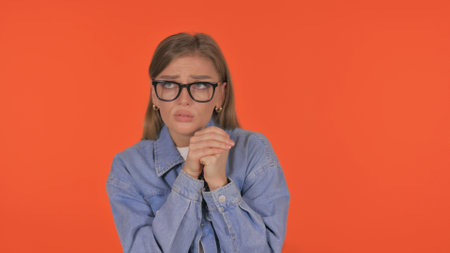Casual Young Woman Feeling Scared on Orange Background, Portraitの写真素材