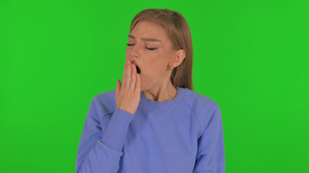 Yawning Woman on Green Backgroundの写真素材