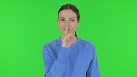 Woman with Silence Gesture on Green Backgroundの写真素材