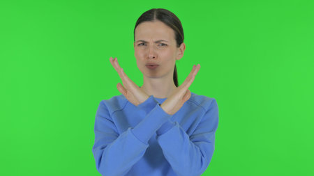 Tense Woman in Denial on Green Backgroundの写真素材