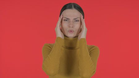Casual Young Woman with Migraine on Red Background, Portraitの写真素材