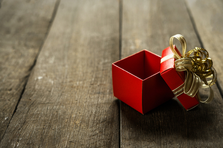 Open red gift box on wood desk with copy space for text placeholder.の写真素材