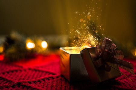Christmas gift with gold particles magic lights.