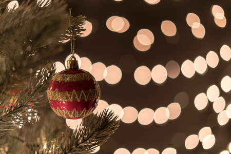 Christmas ball on tree on bokeh lights background with copyspaceの写真素材