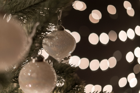Christmas ball on fir tree with bokeh lights background with copyspaceの写真素材