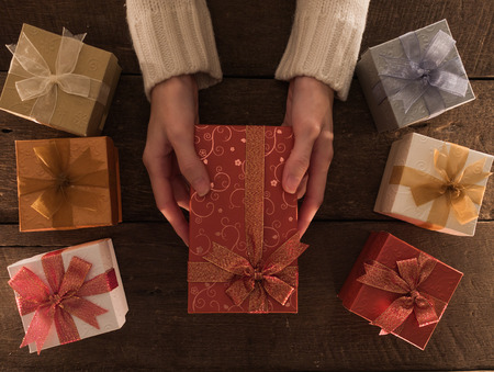 Hand woman holding gift box christmas on wooden desk.の写真素材