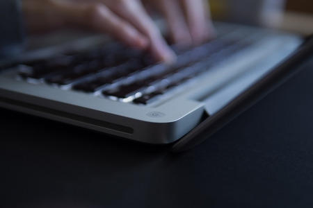 Blurry female's hand typing on laptop.の写真素材