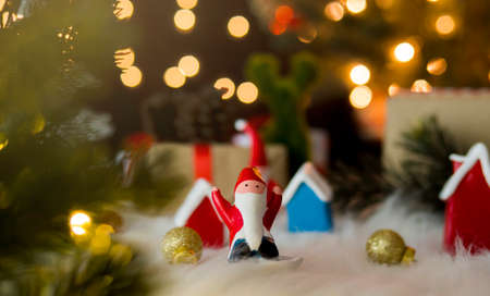 Santa claus dolls and christmas decorations against bokeh lights background.の写真素材