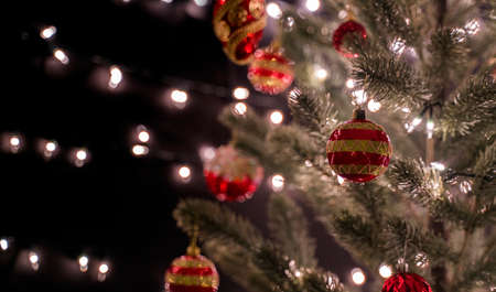 Beautiful decorated christmas tree with ornament against bokeh lights in living room at night.
