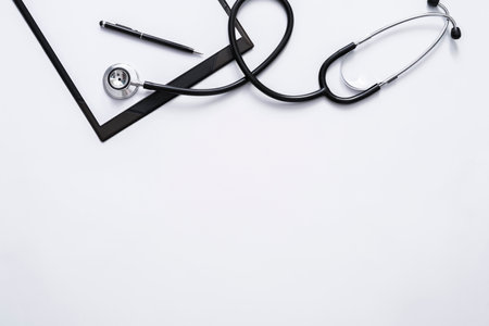 Flat lay of doctor desk with stethoscope, clipboard and pen with copy space for text.の写真素材