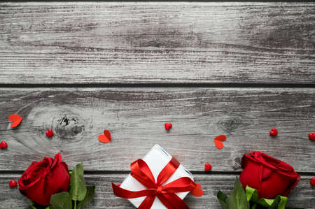 Valentine day background with roses, heart and gift box on wooden table with copy space. View from...