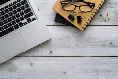 Laptop and notebook on white wood table for business office work desk background with copyspace.の写真素材