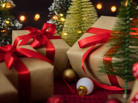 Close up of christmas presents and decorations against bokeh lights background.の写真素材
