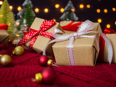 Beautiful gift boxes, baubles and christmas tree against bokeh lights background.の写真素材